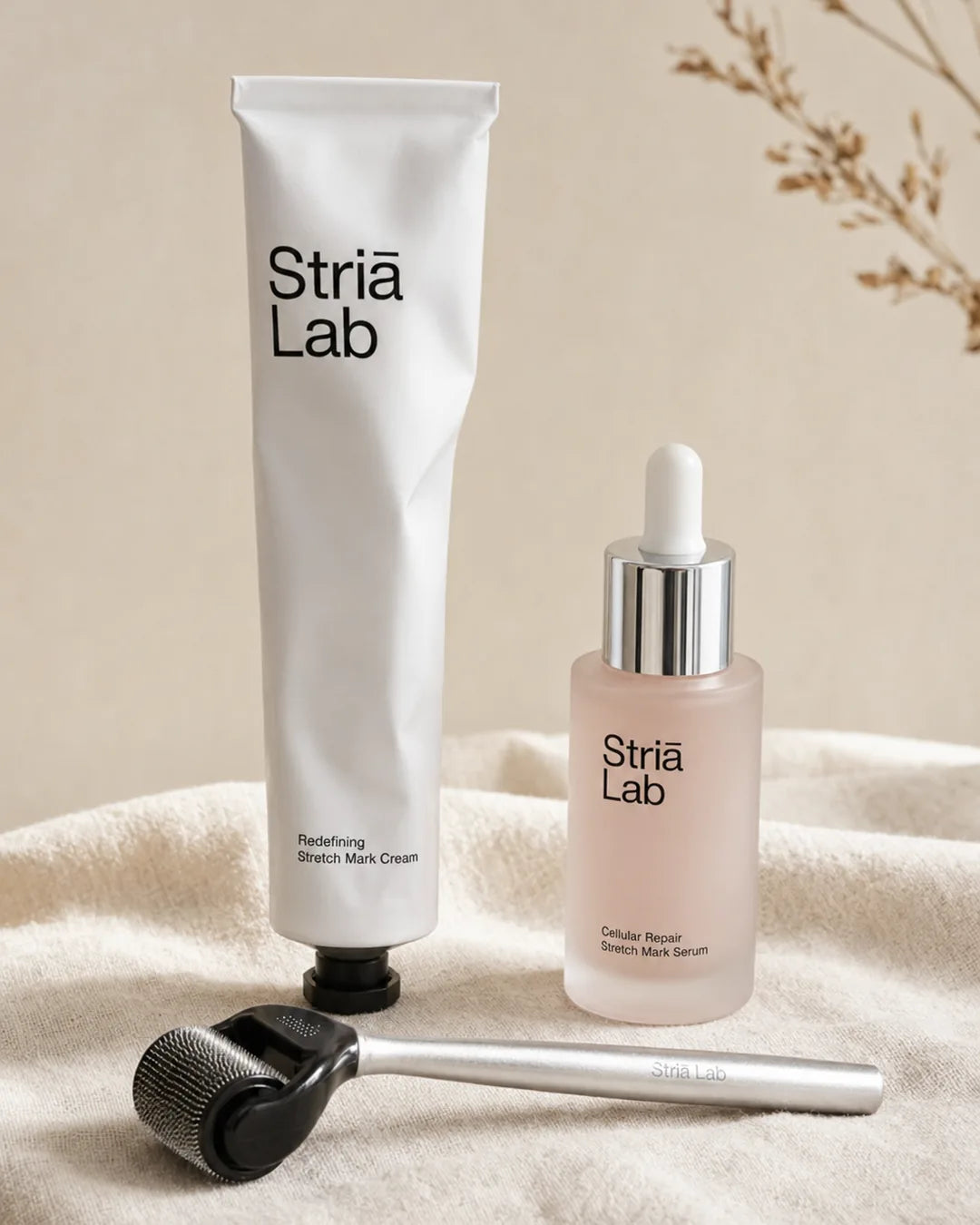 The three-piece Striā Lab Programme: Redefining Cream, Cellular Repair Serum, and microneedling tool on a warm cream background.